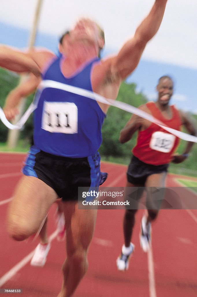 Men reaching finish line of sprint