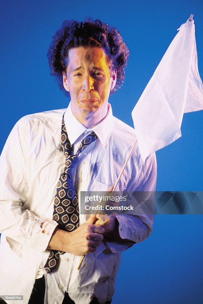 Businessman holding up white flag