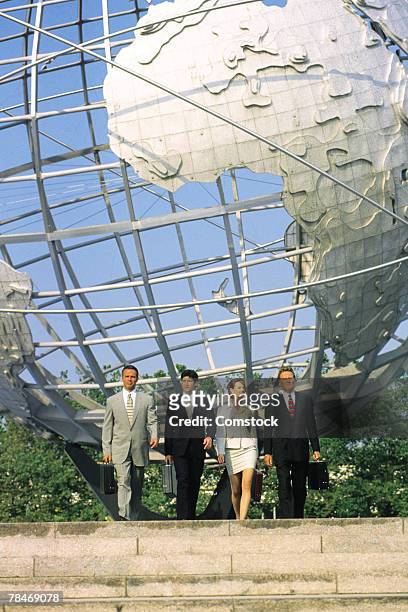 businesspeople with globe sculpture in background - flushing queens stockfoto's en -beelden
