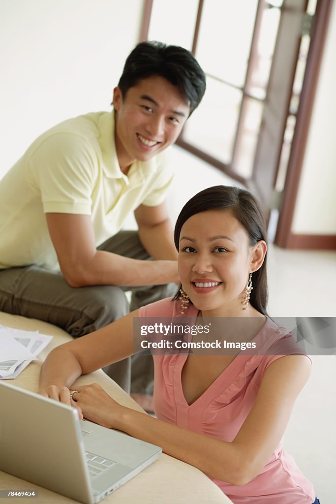 Smiling man and woman with laptop