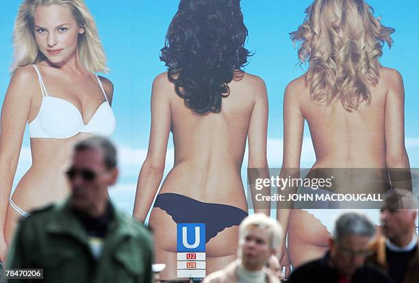 Picture taken 30 March 2007 shows people walking past a billboard advertising lingerie in Berlin 30 March 2007. THE German government announced the...