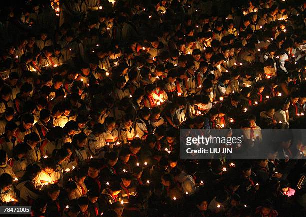 Students light the candles during a memorial event marking the 70th anniversary of Nanjing massacre at the Memorial Hall of the Victims in Nanjing...