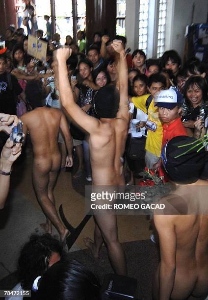 Crowd of students watch nude members of the Alpha Phi Omega fraternity parade during their traditional "oblation run" at the University of the...