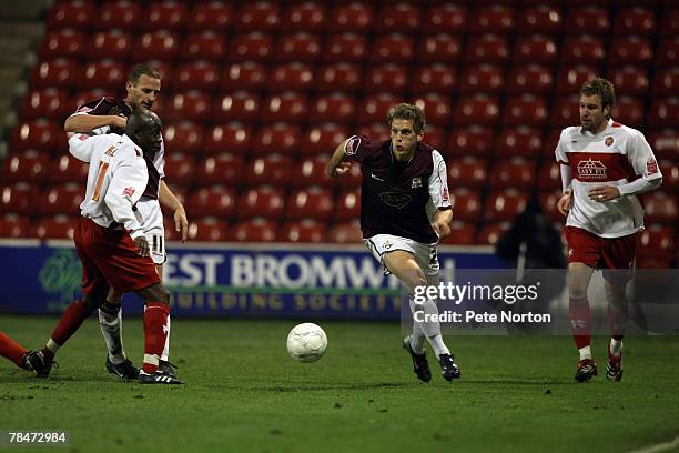 Daniel Jones of Northampton Town moves away with the ball between Paul Hall and Rhys Weston of Walsall during the F.A.Cup Sponsored by E.ON Second...