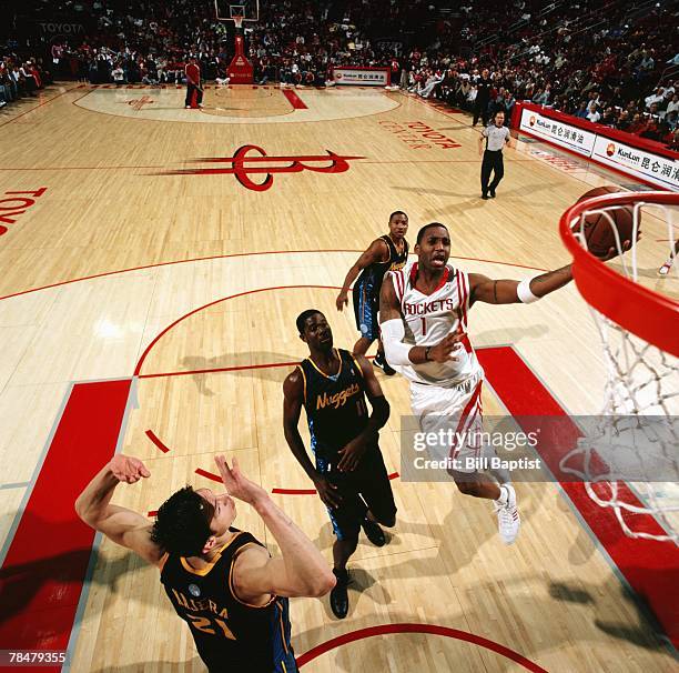 Tracy McGrady of the Houston Rockets drives to the basket for a layup against Bobby Jones of the Denver Nuggets during the game at the Toyota Center...