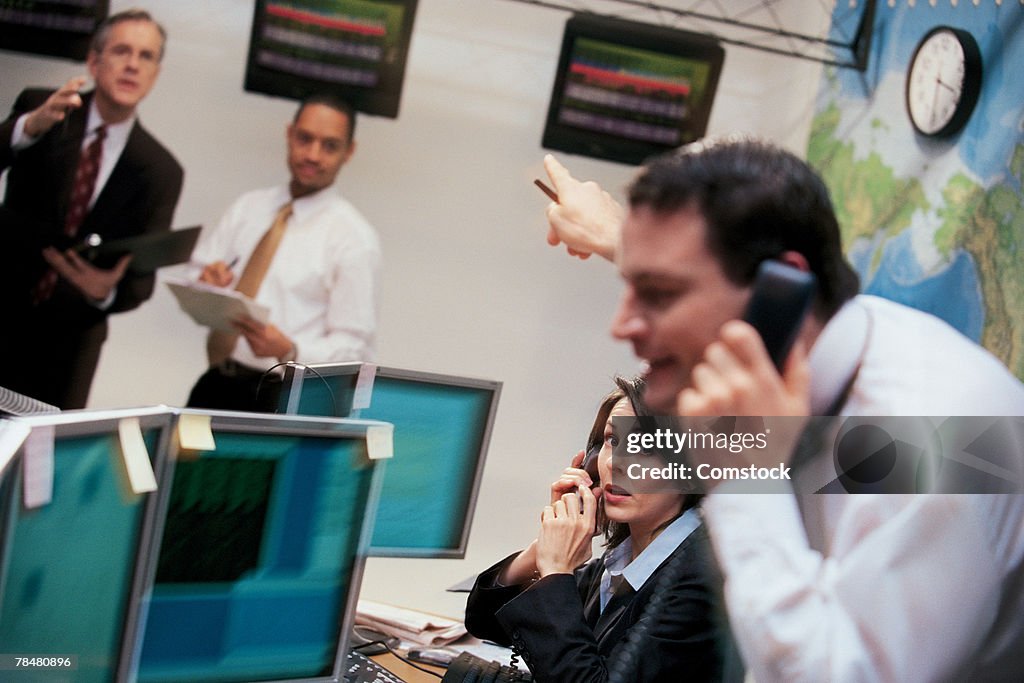 Stock brokers in office on phones