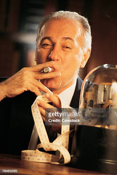 businessman smoking cigar by stock ticker - 2003 stock photos et images de collection