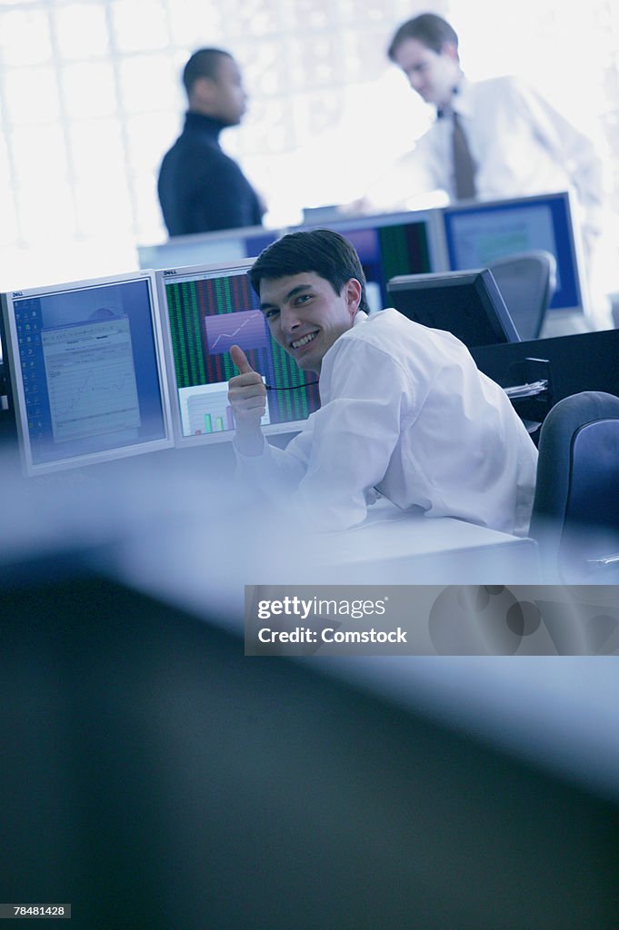 Businessmen in office making thumbs up gesture