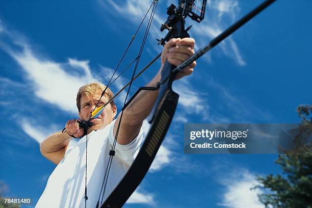 man with bow and arrow - target sport stock pictures, royalty-free photos & images