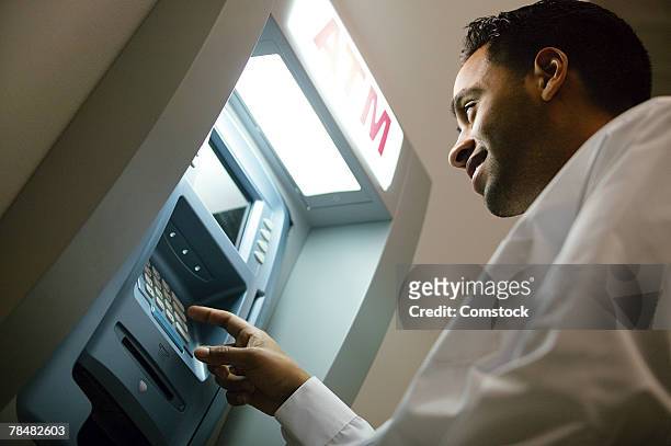 man using atm - man atm smile stock pictures, royalty-free photos & images