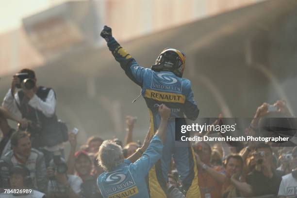 Fernando Alonso of Spain and driver of the Mild Seven Renault F1 Team Renault R25 Renault RS25 V10 is held up by team principal Flavio Briatore as...