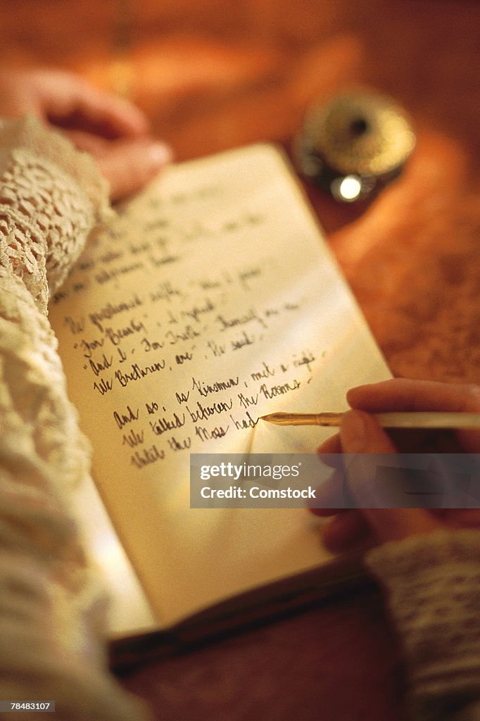 Woman writing in diary with ink pen