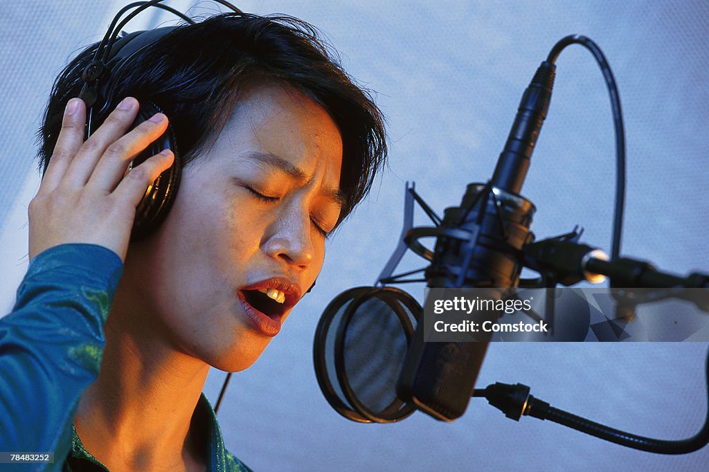 Young singer recording in studio