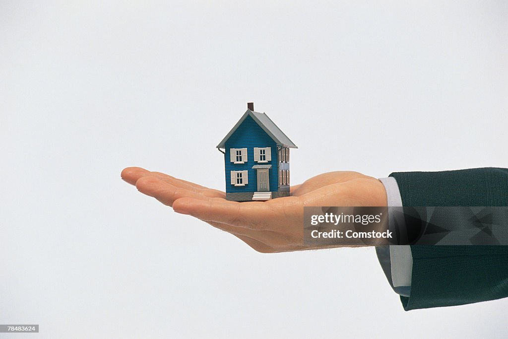 Hand holding model house