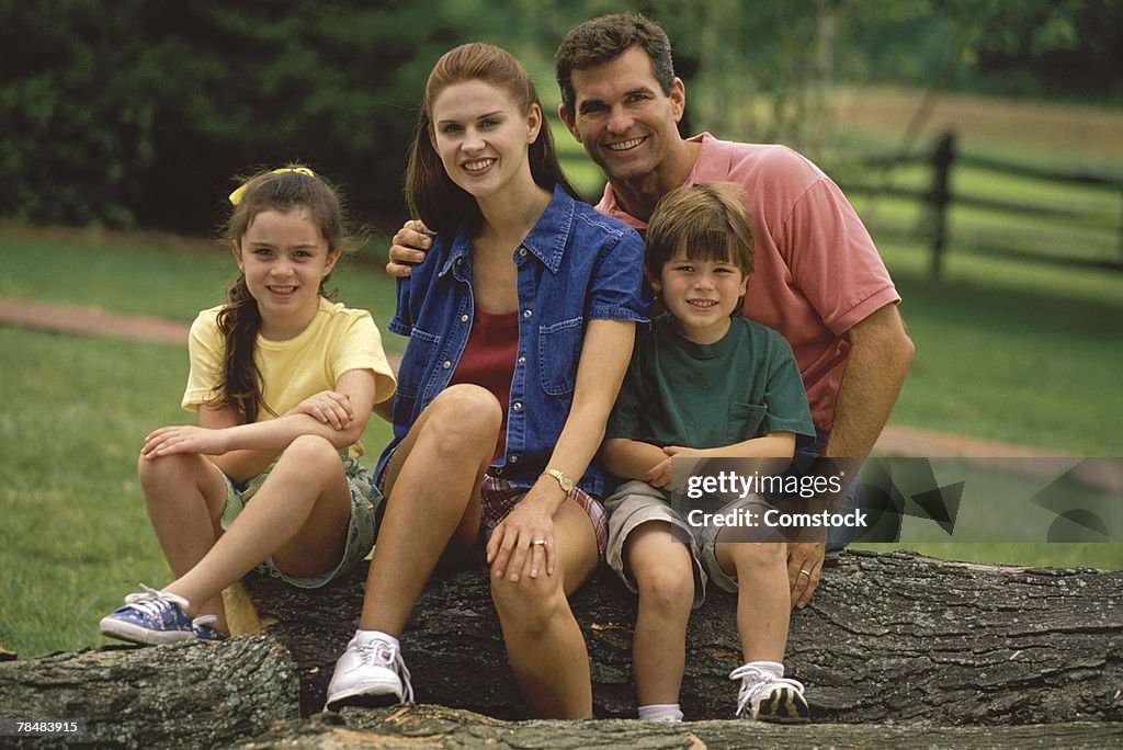 Family sitting on a tree trunk