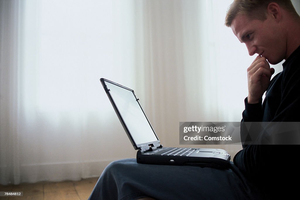 Man sitting with laptop on lap