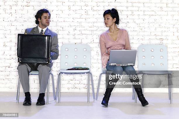 opposite styles of businesspeople in waiting room - interview funny stockfoto's en -beelden