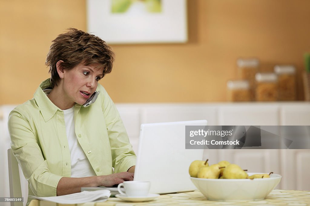 Woman using mobile phone and laptop