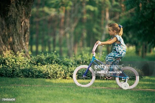 girl riding a bicycle - stützrad stock-fotos und bilder