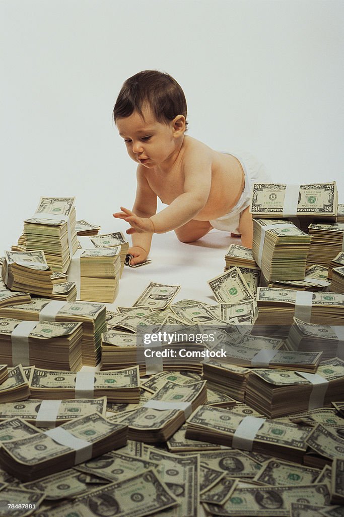 Baby crawling on pile of money