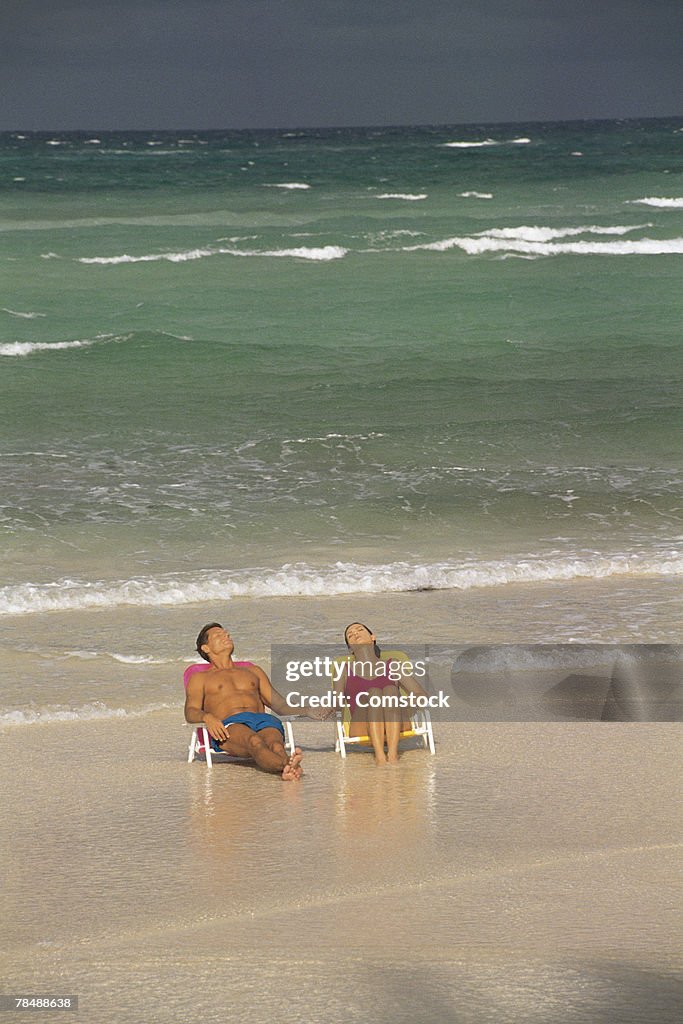 Couple holding hands and basking on a beach