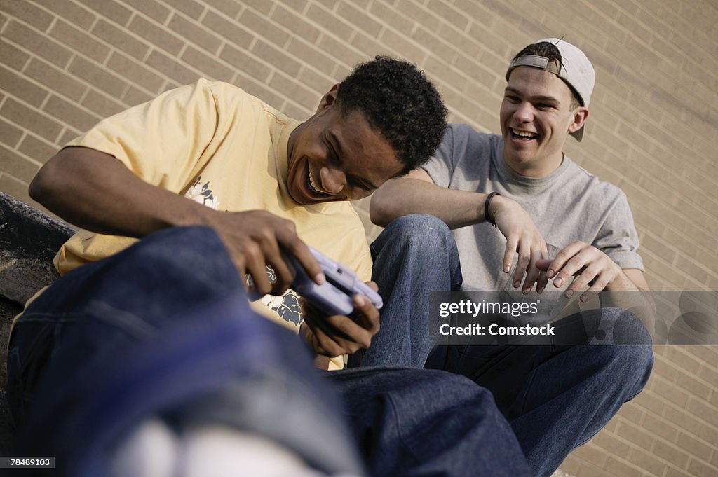 Teenage boys with a handheld video game