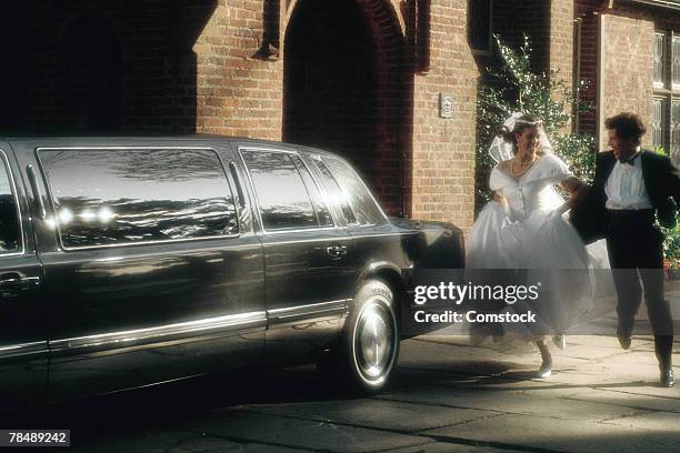 bride and groom running to limousine - wedding limo stock pictures, royalty-free photos & images