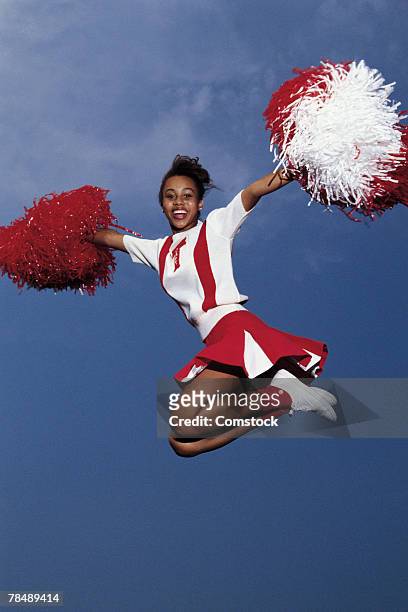 cheerleader in mid-air - teen cheerleader stock-fotos und bilder