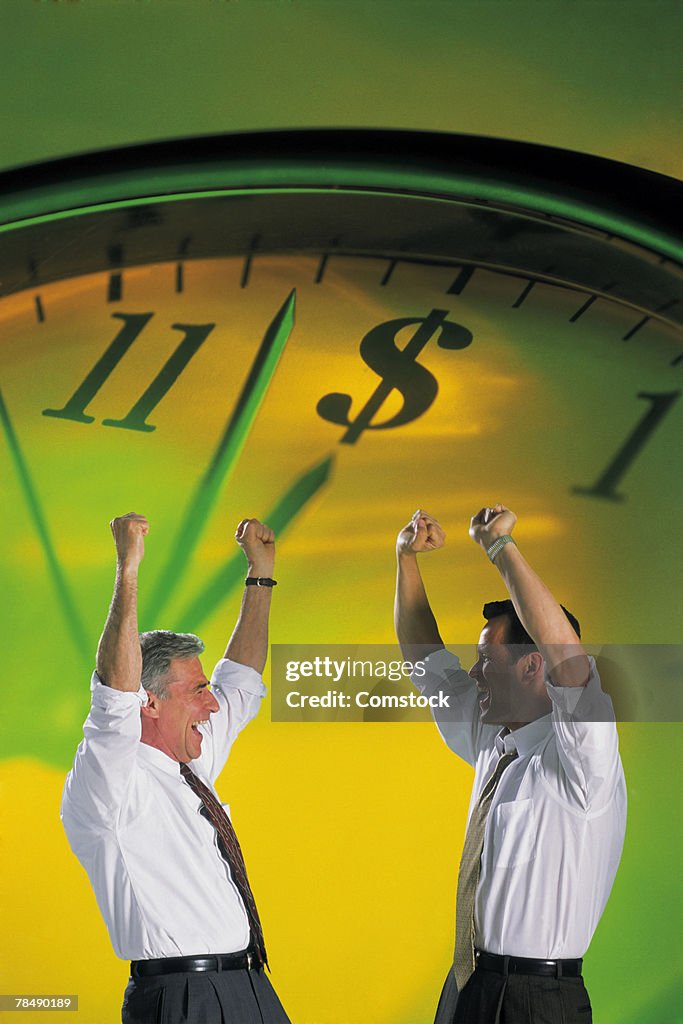 Businessmen cheering with clock