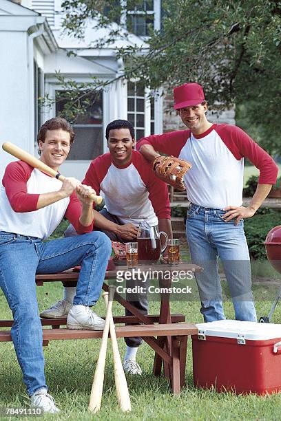 men with baseball gear posing in backyard - backyard baseball stock-fotos und bilder