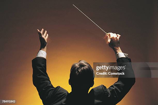 music conductor with baton - orquestra imagens e fotografias de stock