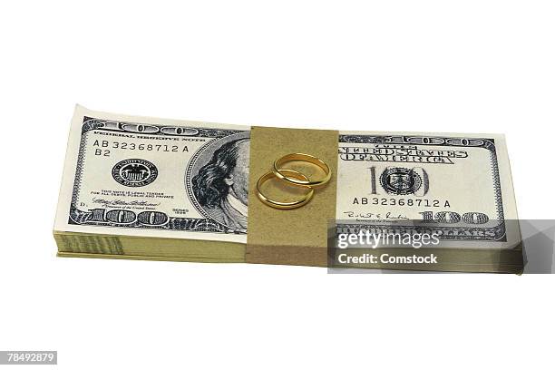 stack of dollar bills with wedding bands - married money stock pictures, royalty-free photos & images