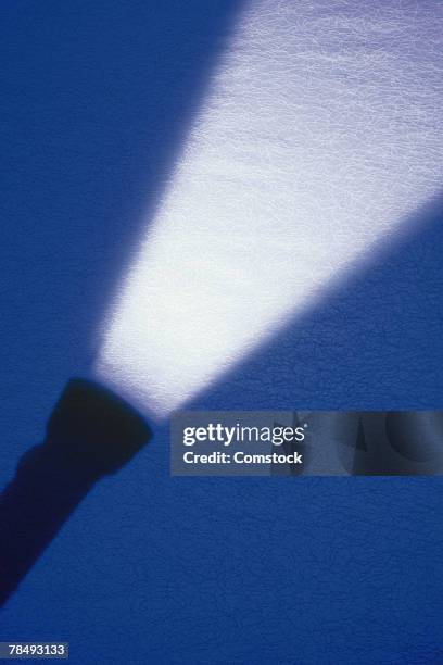 silhouette of shining flashlight - flashlight stockfoto's en -beelden