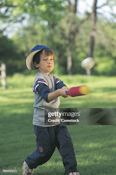 boy hitting baseball in backyard - backyard baseball stockfoto's en -beelden