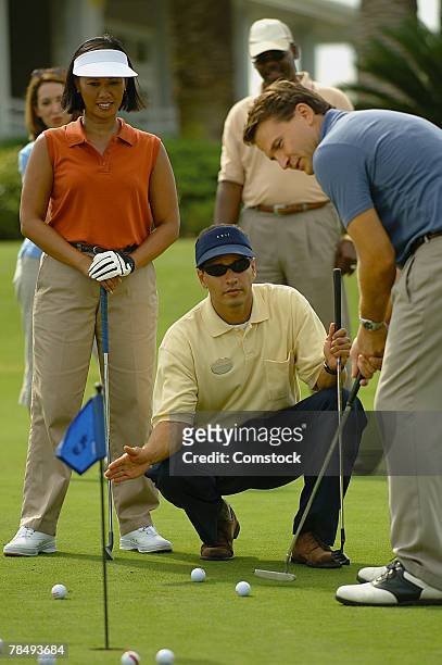 golf instructor teaching a putting class - golf lessons stock pictures, royalty-free photos & images