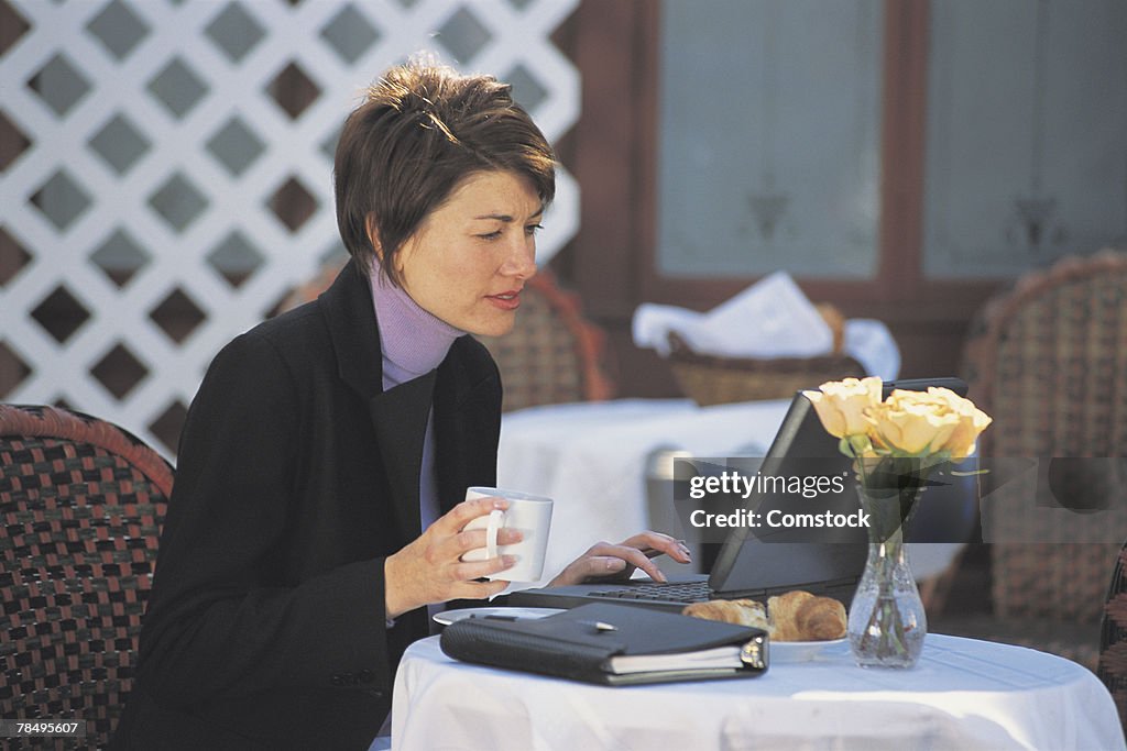 Businesswoman using computer at outdoor cafe