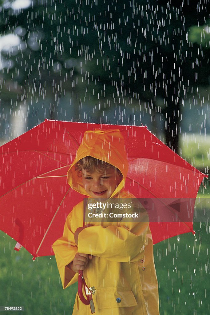 Child with raincoat and umbrella