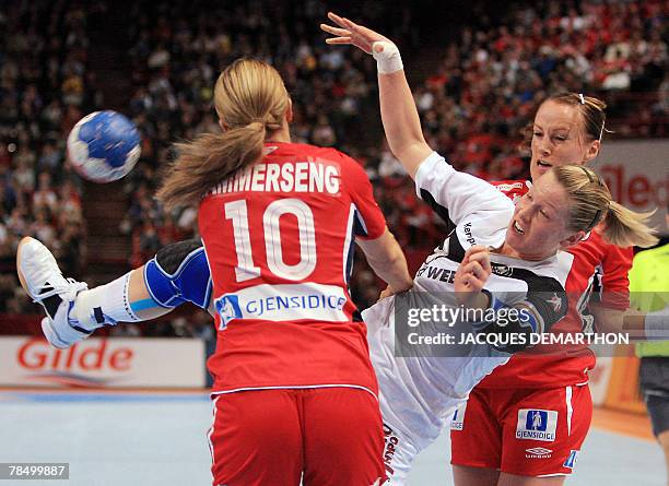 Germany's Nadine Krause vies with Norway's Gro Hammerseng and Ragnhild Aamodt during the women world championship handball semi final match Norway...
