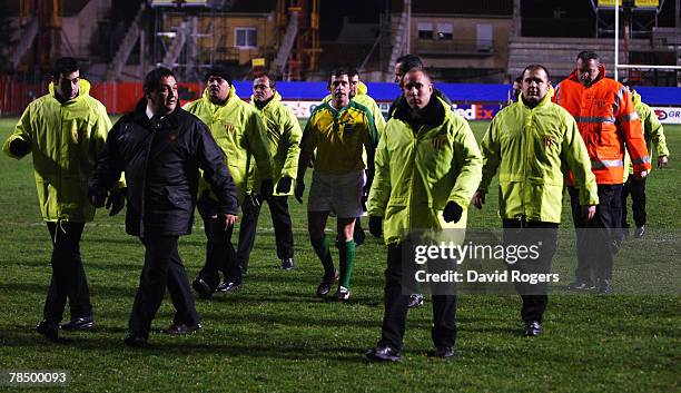 Carlo Damasco, the referee, is escorted off the field by security after the Heineken Cup match between Perpignan and London Irish at Stade Aime Giral...