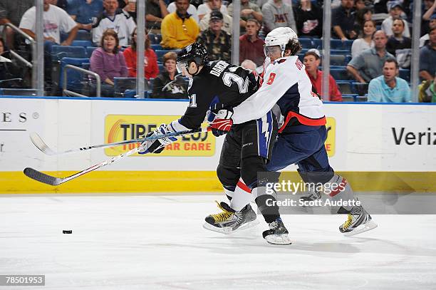 Mathieu Darche of the Tampa Bay Lightning battles against Alexander Ovechkin of the Washington Capitals for control of the puck at St. Pete Times...