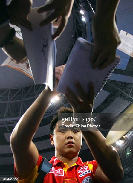 Wang Hao of China signs autographs for fans after his quarterfinal against Samsonov Vladimir of Belarus during the "Good Luck Beijing" 2007...