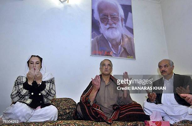 Pakistani former prime minister Benazir Bhutto prays for late slain rebel tribal chief Nawab Akbar Bugti as Bugti's son Talal Bugti joins her during...