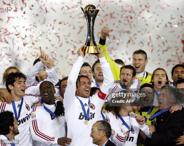 European champions AC Milan captain Paolo Maldini raises the trophy while his teammates celebrate after they defeated South American champions Boca...