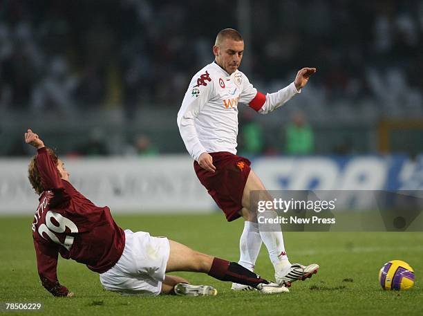 Daniele De Rossi of Roma is tackled by Davide Bottone of Torino during the Serie A match between Torino and Roma at Stadio Olimpico Grande Torino,...