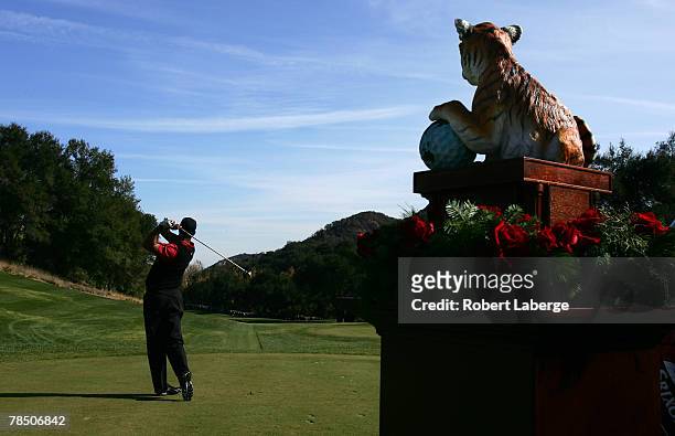 Tiger Woods tees off on the first hole next to the winner's trophy during the final round of the Target World Challenge at the Sherwood Country Club...
