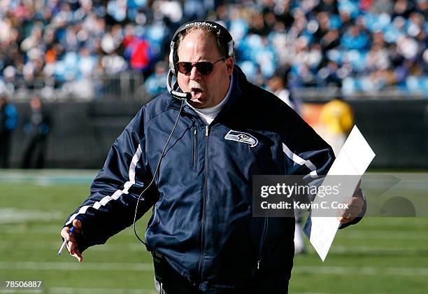 Head coach Mike Holmgren of the Seattle Seahawks talks on the radio during the first half against the Carolina Panthers at Bank of America Stadium on...