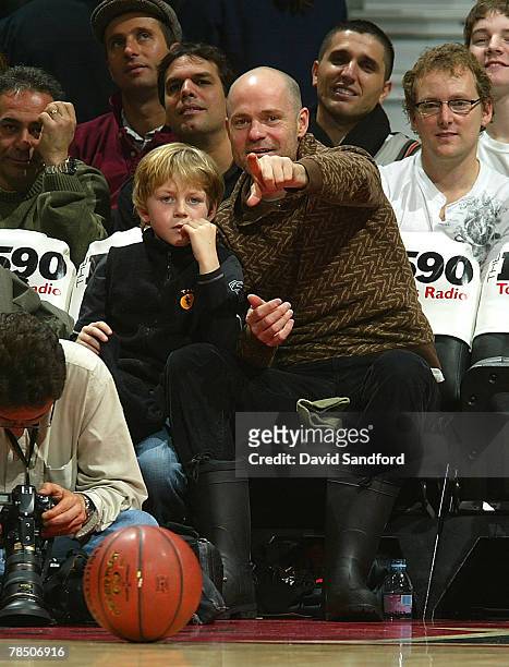 Gord Downie of the Trigically Hip sits with his son as the Boston Celtics face the Toronto Raptors on December 16, 2007 at the Air Canada Centre in...