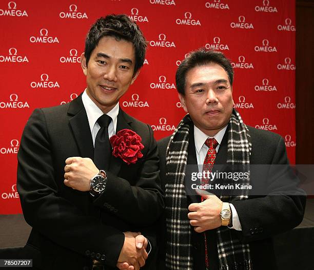 Musical pop star and Omega Ambassador Richie Jen poses with a cutomer at the Carat & Karat store on December 15, 2007 in Queens, New York City.