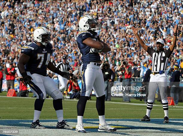 Shaun Phillips of the San Diego Chargers celebrates his interception for a touchdown against the Detroit Lions as he is joined by teammate Jacques...