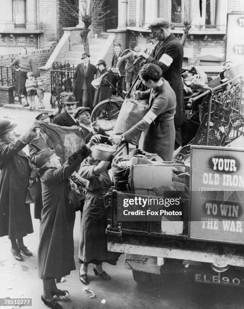 Local residents handing over scrap metal and waste paper during a wartime salvage collection in Hammersmith, London, circa 1943.